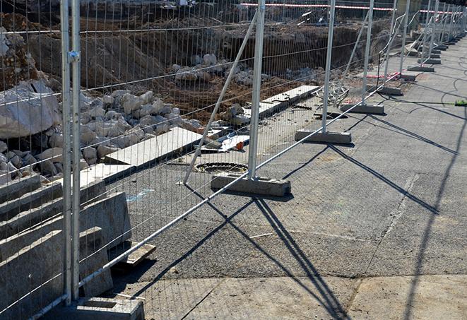 a temporary fence panel erected around an excavation site for safety purposes